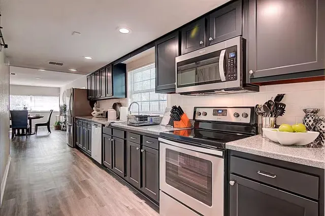 a kitchen with stainless steel appliances a stove a sink and a microwave