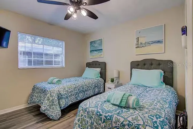 a bedroom with two beds and painting on the wall