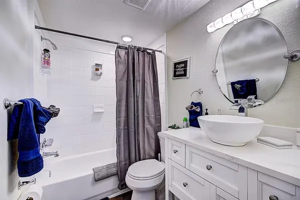 a bathroom with a sink a toilet and a large mirror
