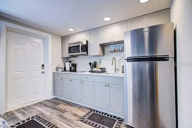 a kitchen with stainless steel appliances a refrigerator sink and microwave