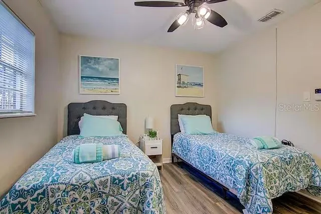 a bedroom with two beds and a chandelier