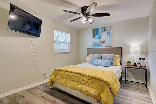 a bedroom with a bed a flat screen tv and a chandelier