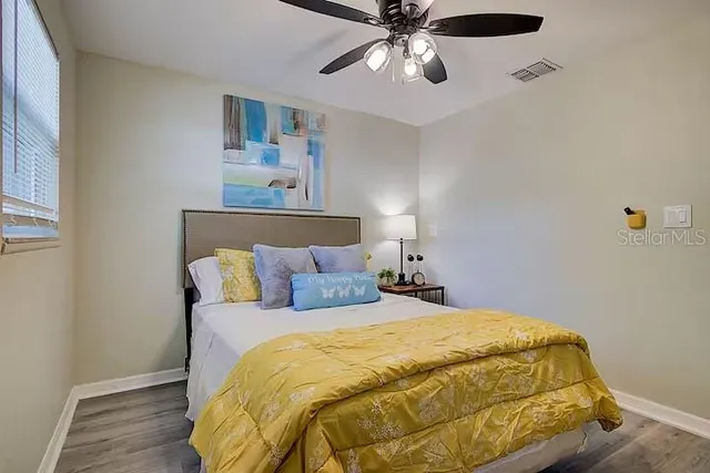 a bedroom with a bed and wooden floor