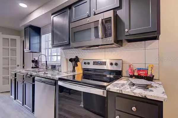 a kitchen with stainless steel appliances granite countertop a stove microwave and cabinets