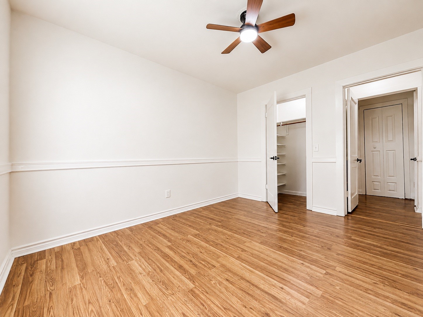 316 Riley Road Clute, TX 77531 - Photo 8 of 21 Spacious bedroom with elegant wood style flooring, a modern ceiling fan, and ample closet space for organization.