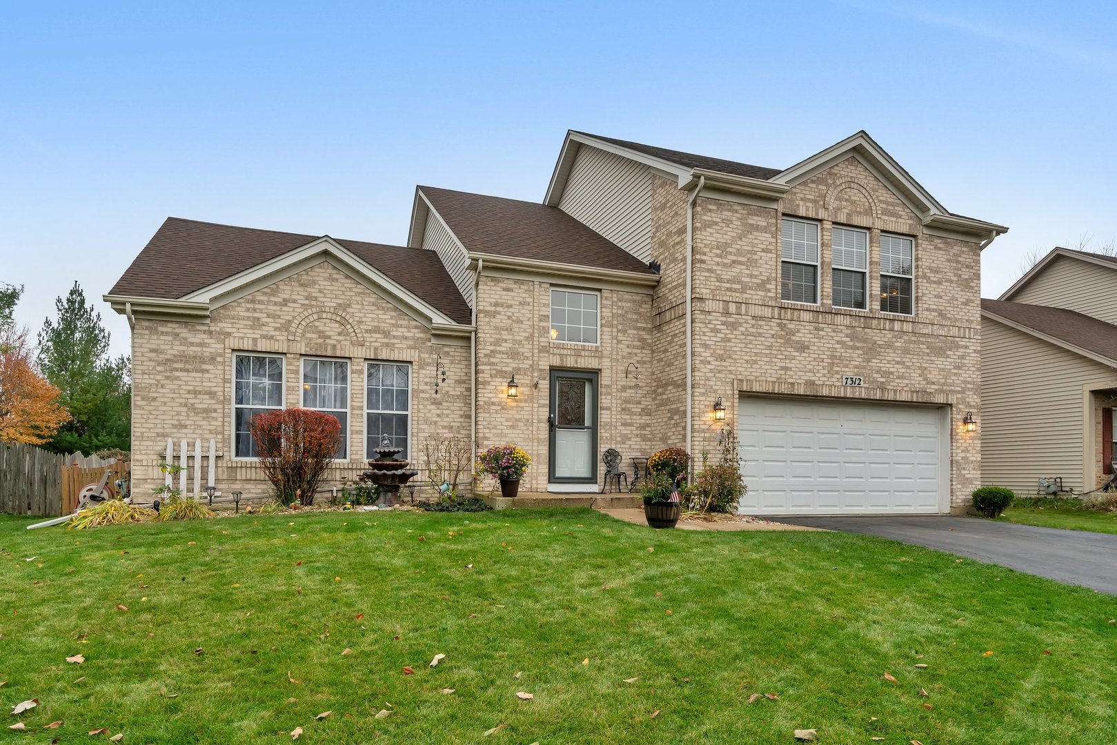 7312 Atkinson Circle Plainfield, IL 60586 - Photo 2 of 27 a front view of a house with a garden and yard