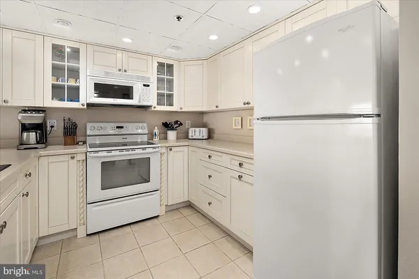a kitchen with stainless steel appliances white cabinets and white appliances