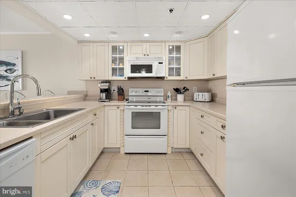 a kitchen with stainless steel appliances granite countertop a sink and dishwasher a stove top oven with white cabinets