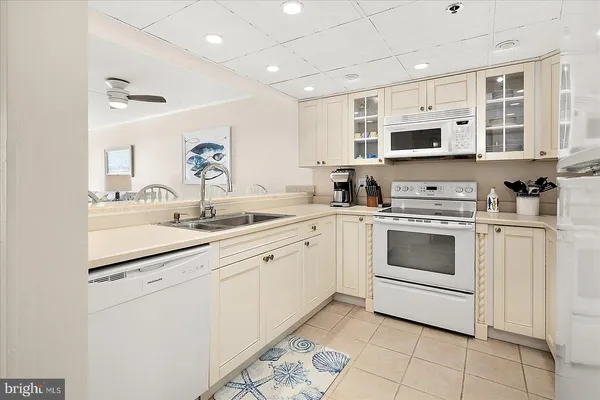 a kitchen with stainless steel appliances granite countertop white cabinets a sink and dishwasher