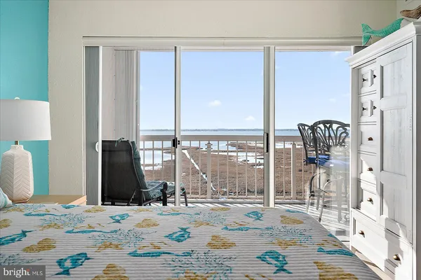 a view of a bedroom with wooden floor and windows