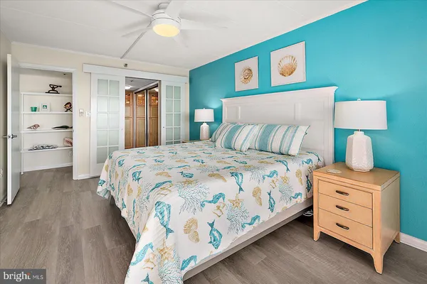 a bedroom with a bed and a lamp on dresser