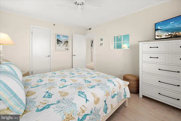 a bedroom with a bed and a tv on the dresser