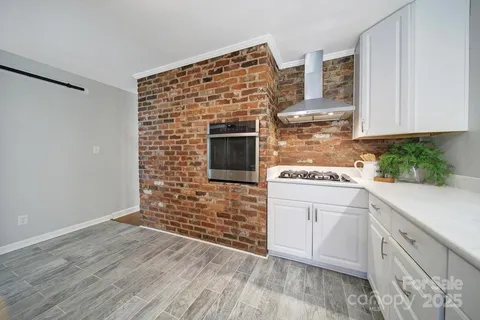 a kitchen with cabinets and wooden floor