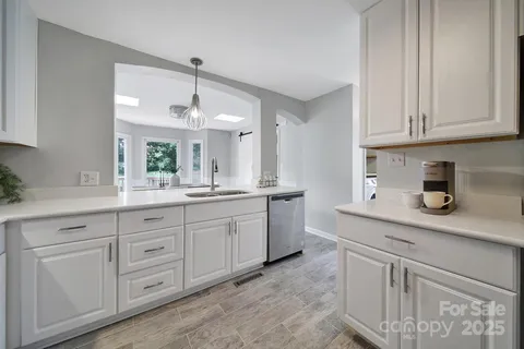 a kitchen with white cabinets and sink
