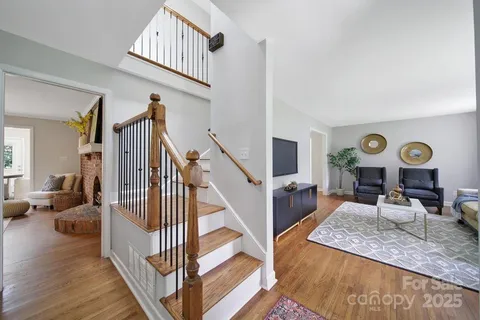 a view of a livingroom with furniture wooden floor windows and a clock
