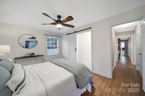a bedroom with a large bed and a chandelier
