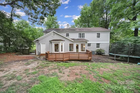a view of a house with a yard and a tree