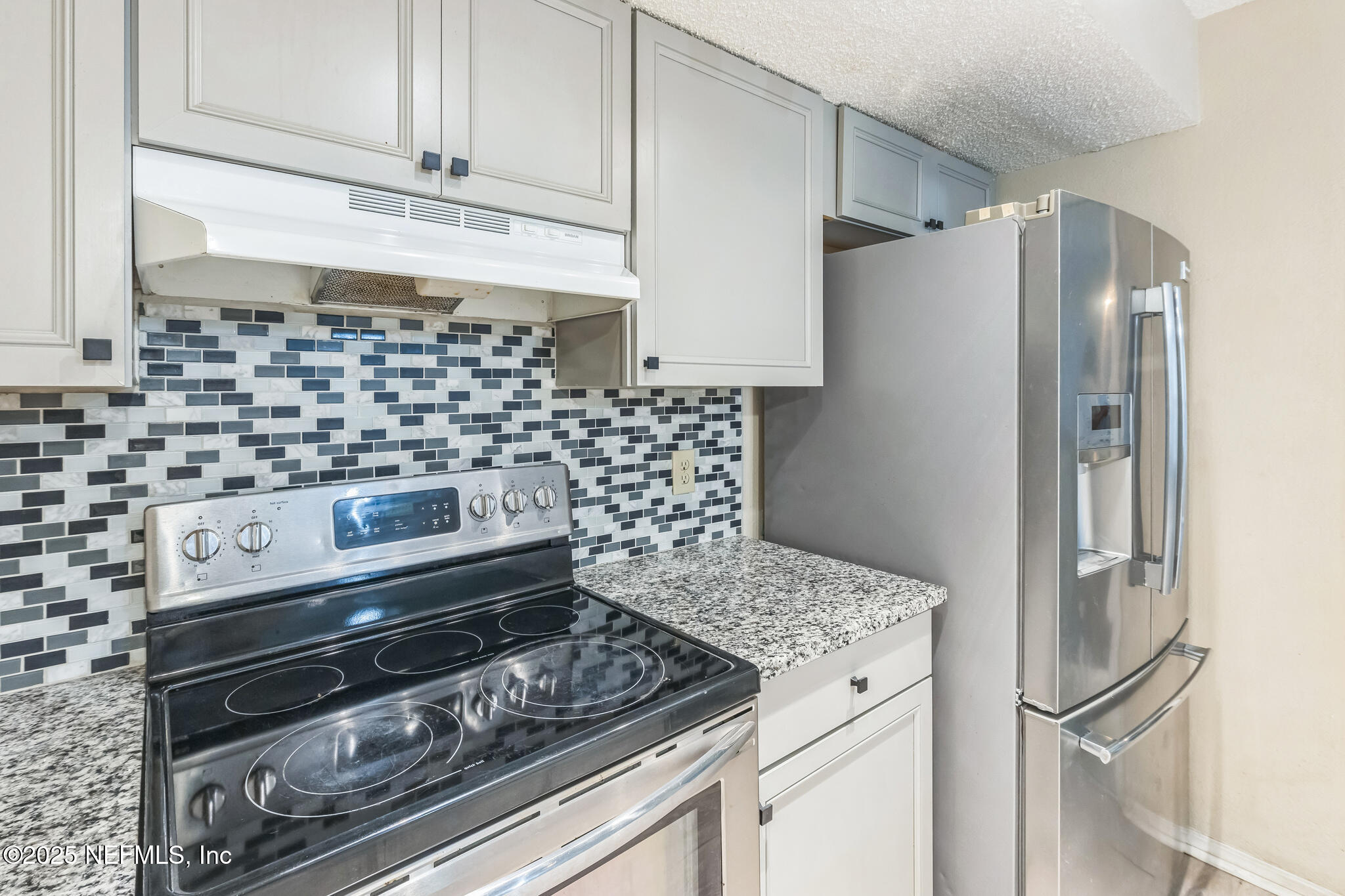 4777 Barnes Road South Jacksonville, FL 32207 - Photo 5 of 15 a kitchen with granite countertop a stove and a refrigerator