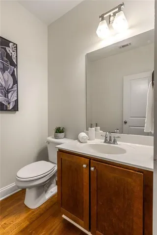 a bathroom with a granite countertop toilet sink and mirror
