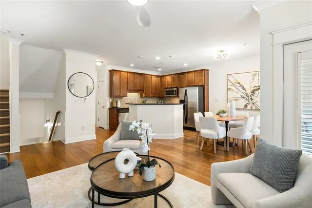 a living room with furniture a table and kitchen view