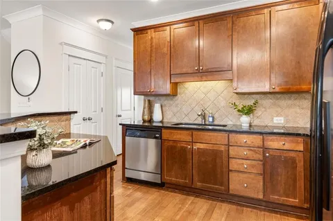 a kitchen with granite countertop a sink a stove and cabinets