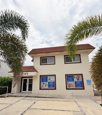 a front view of a house with a tree