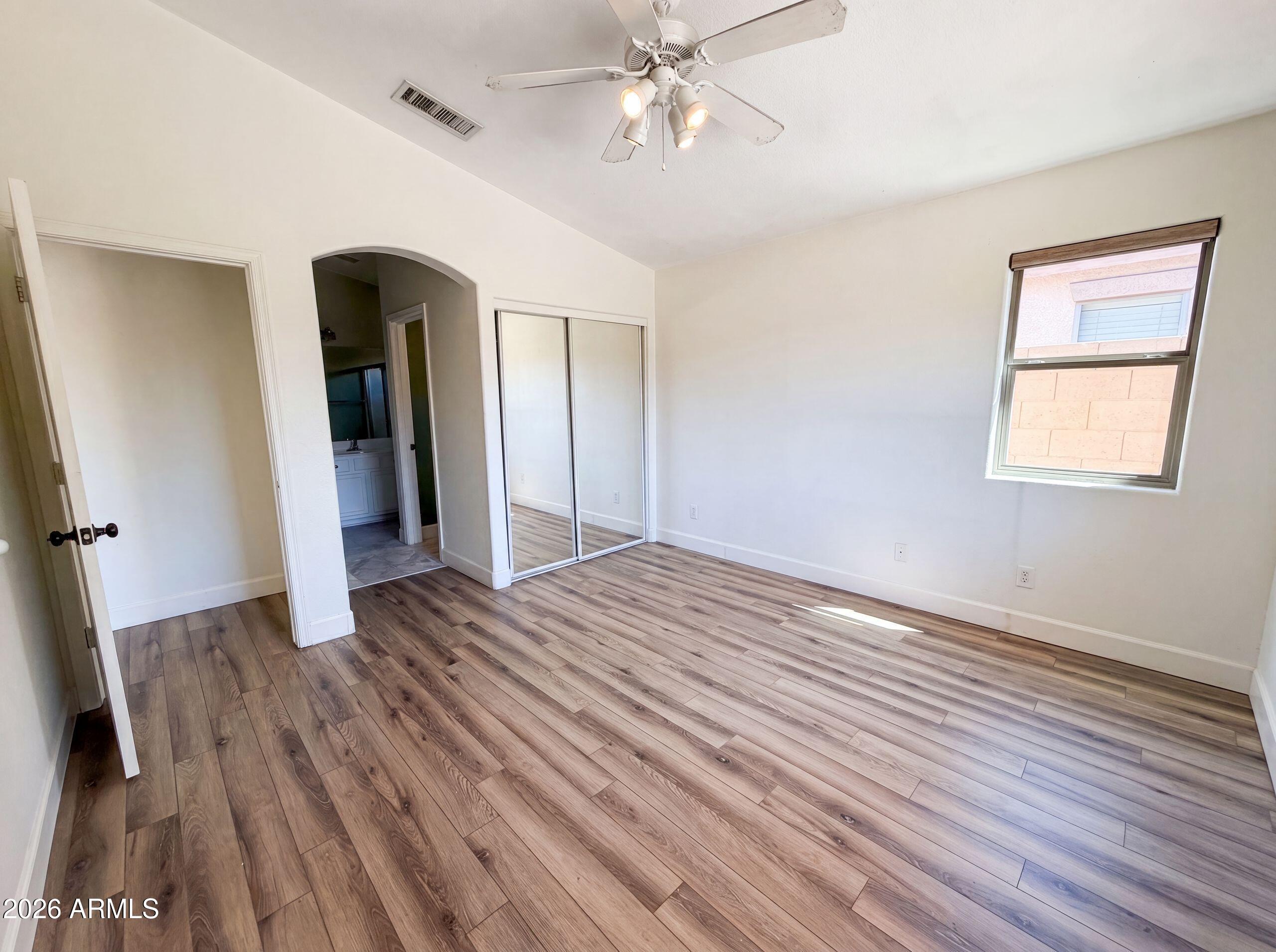 3951 East Timberline Road Gilbert, AZ 85297 - Photo 16 of 28 a view of an empty room with wooden floor and a ceiling fan