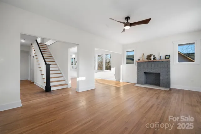 a view of a livingroom with wooden floor and a ceiling fan