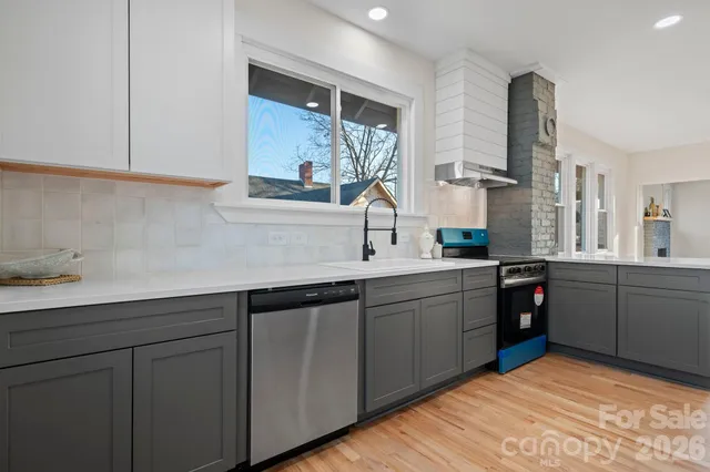 an empty room with wooden floor a ceiling fan and fireplace