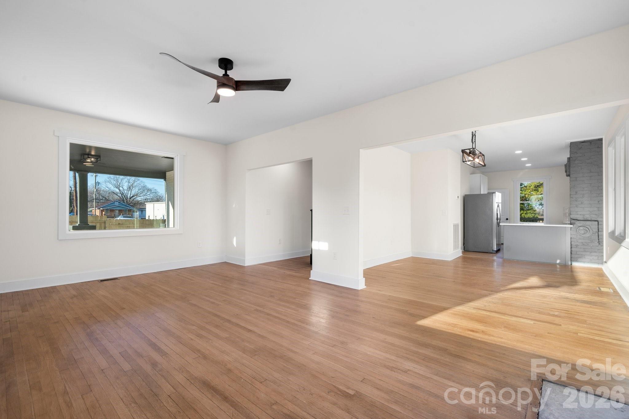 49 8th Street Southeast Hickory, NC 28602 - Photo 4 of 39 a view of an empty room with wooden floor and a ceiling fan