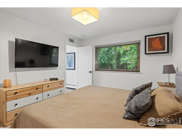 a bedroom with a bed and a painting on the wall