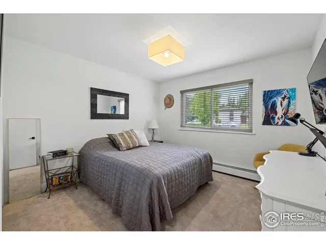a bedroom with a bed and a dresser next to a window