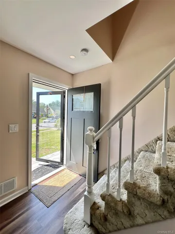 a view of entryway livingroom and hall with wooden floor
