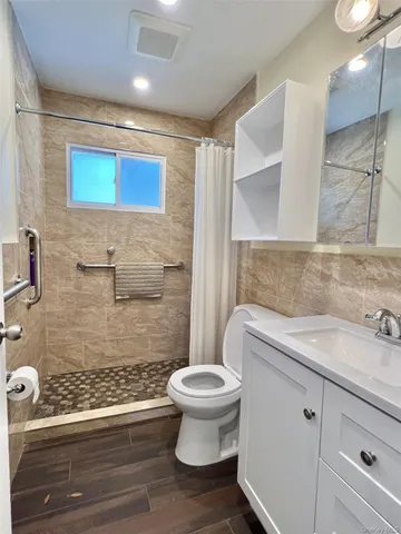 a bathroom with a sink a toilet and shower