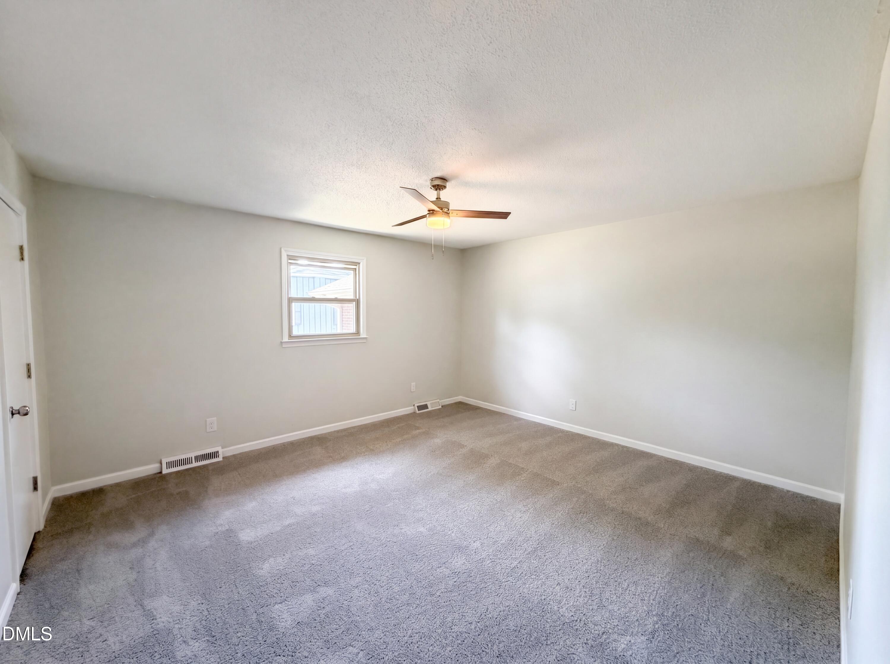 1710 West B Street Butner, NC 27509 - Photo 5 of 14 an empty room with a window and a ceiling fan