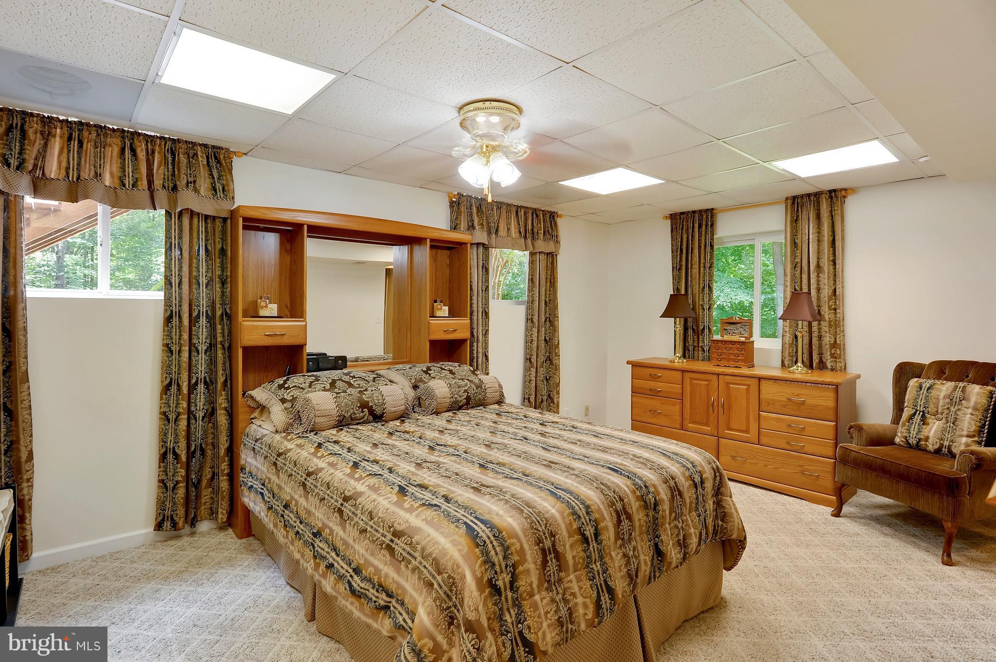 2816 Stinnett Road Huntingtown, MD 20639 - Photo 15 of 27 a bedroom with a bed and a chandelier