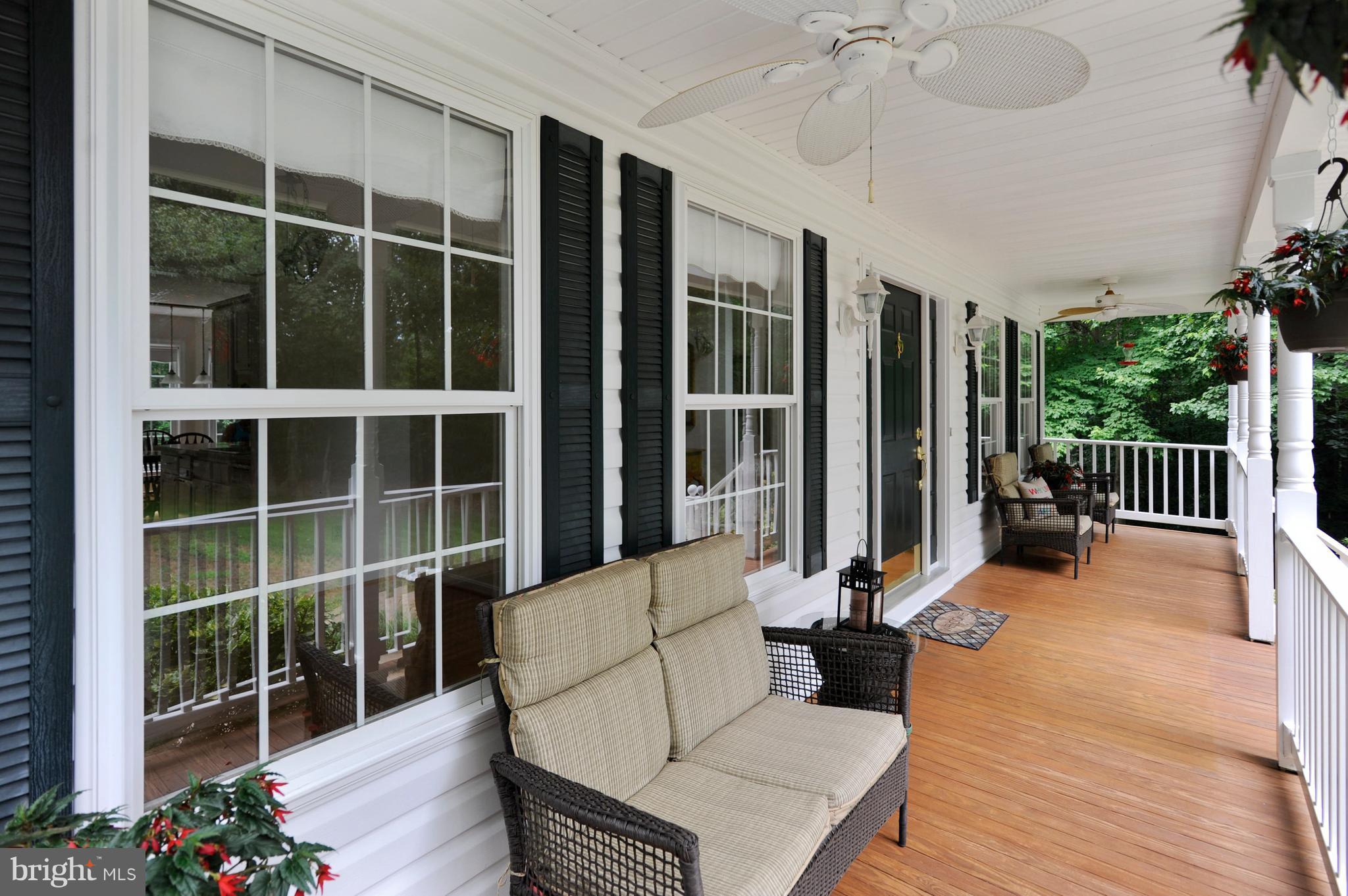 2816 Stinnett Road Huntingtown, MD 20639 - Photo 16 of 27 a view of a deck with couches floor to ceiling window and wooden floor