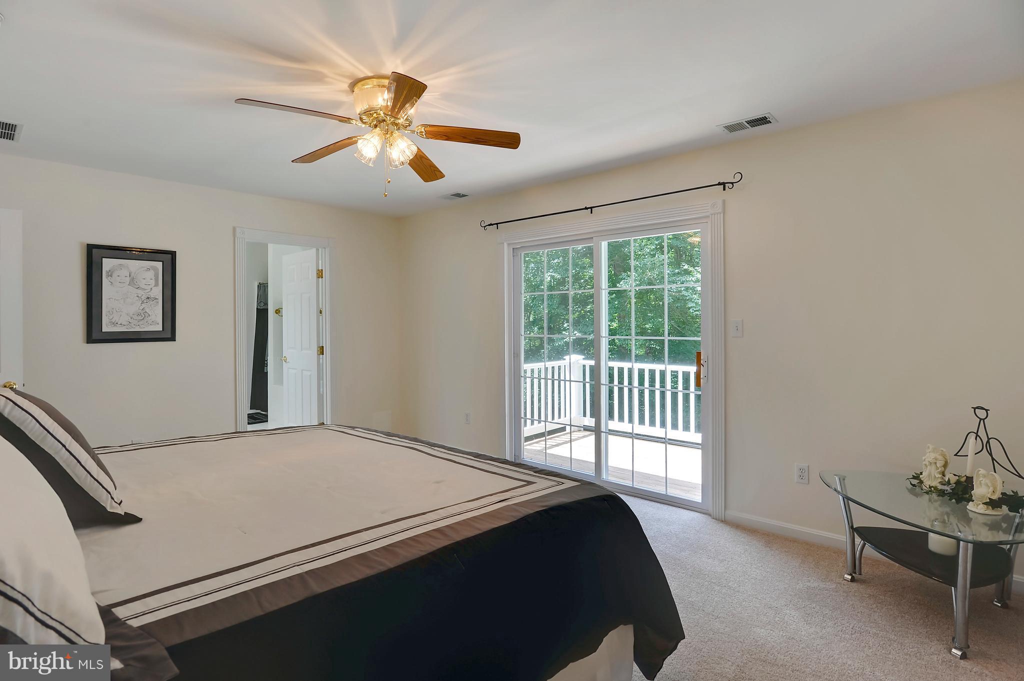 2816 Stinnett Road Huntingtown, MD 20639 - Photo 10 of 27 a bedroom with a bed and a chandelier