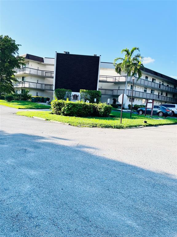 a view of a house with a yard and a large parking space