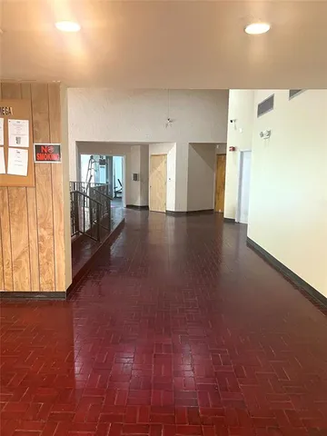 a view of a hallway with wooden floor and cabinet
