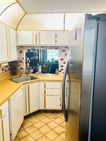 a view of a refrigerator in kitchen and utility