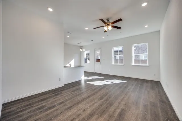 a view of empty room with wooden floor and windows