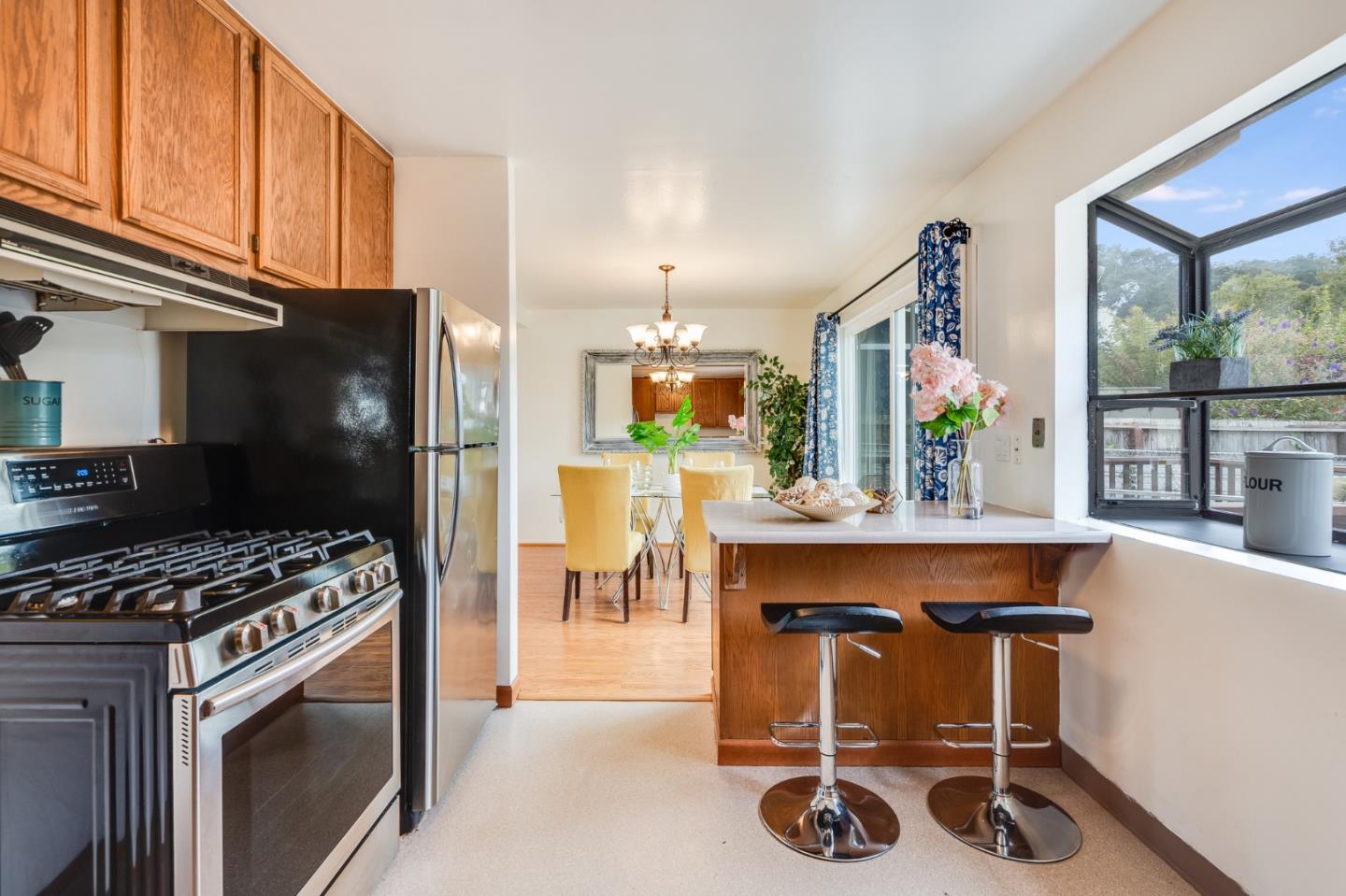 1376 Peralta Road Pacifica, CA 94044 - Photo 13 of 35 a kitchen with kitchen island stainless steel appliances a table chairs and a refrigerator