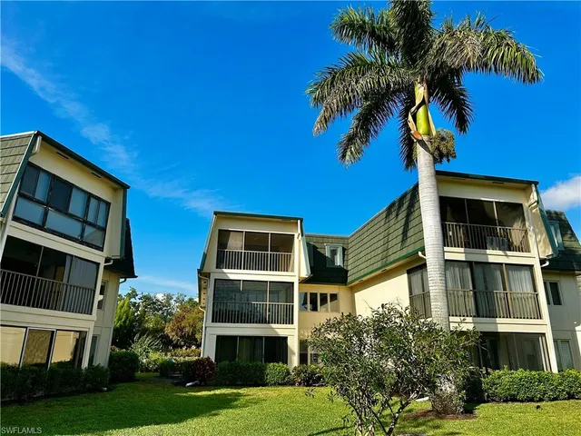 a front view of a house with a yard and potted plants