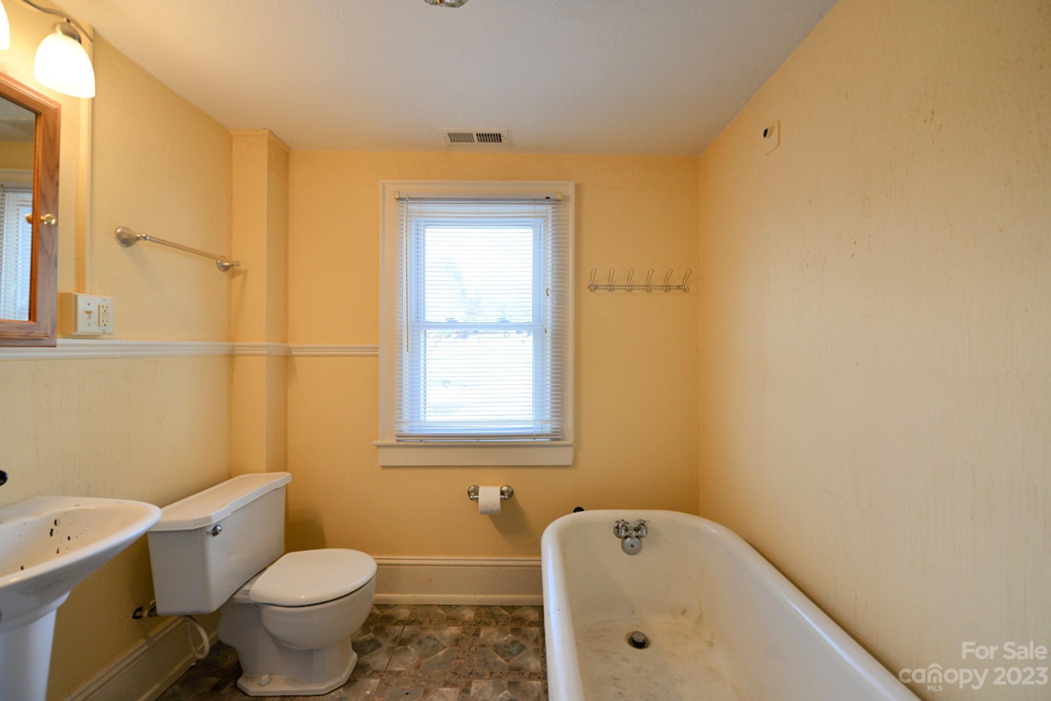 160 Edwards Road Clyde, NC 28721 - Photo 11 of 17 a white toilet sitting next to a bathroom sink and tub