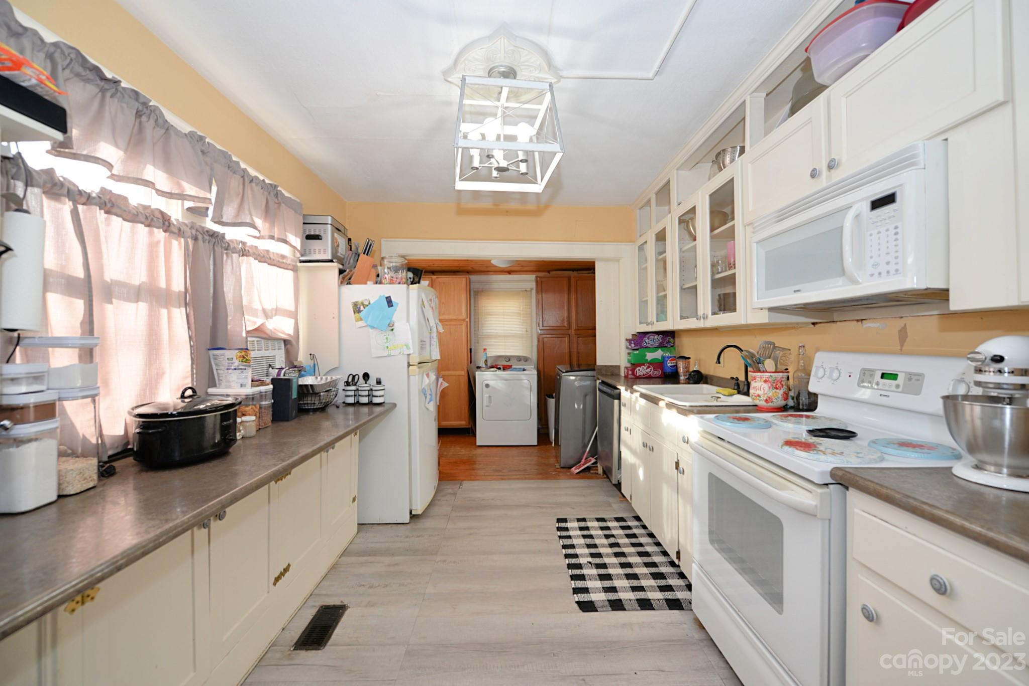 160 Edwards Road Clyde, NC 28721 - Photo 7 of 17 a kitchen with stainless steel appliances a stove a sink and white cabinets
