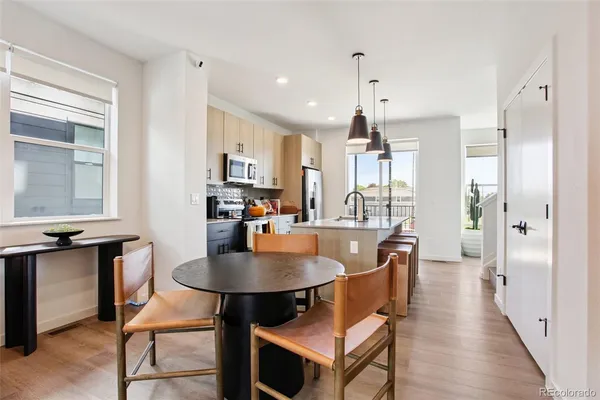a dining room with furniture a chandelier and wooden floor