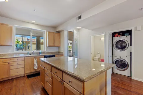 a kitchen with granite countertop a sink a stove and cabinets