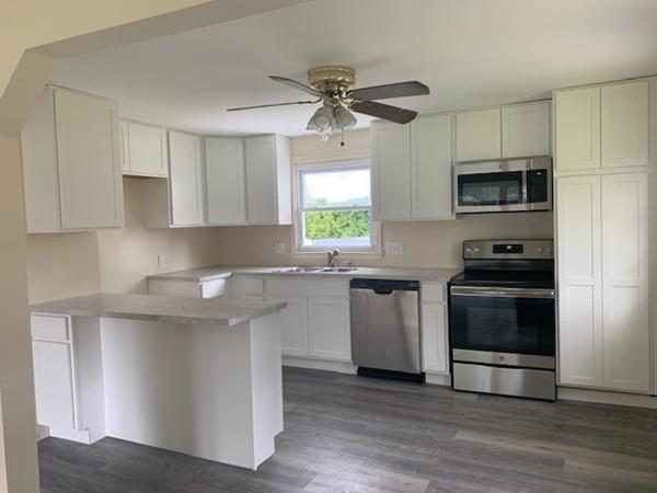 53 Moss Road Springfield, MA 01119 - Photo 2 of 15 a kitchen with granite countertop a stove a sink and a microwave