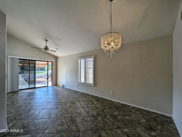 a view of a livingroom with a chandelier fan and windows